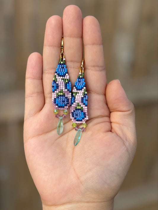 Hand holding a pair of handmade beaded earrings with Miyuki Delica and Czech glass beads.