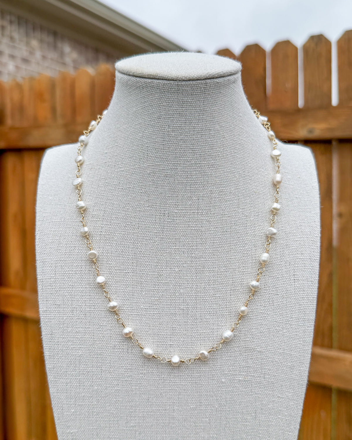 Beaded necklace featuring handmade gold wire links with pearls.