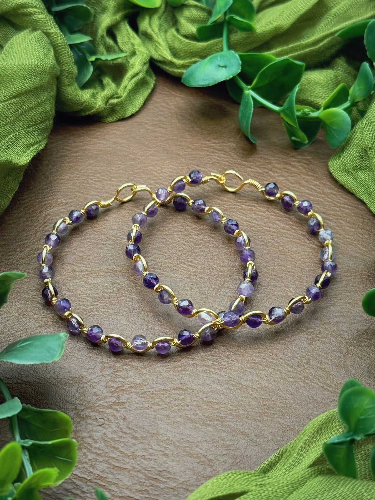 Handmade, wire-wrapped bracelet shaped like a wave, featuring amethyst purple beads.