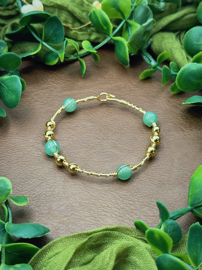 Handmade wire-wrapped bangle bracelet with quartz beads.