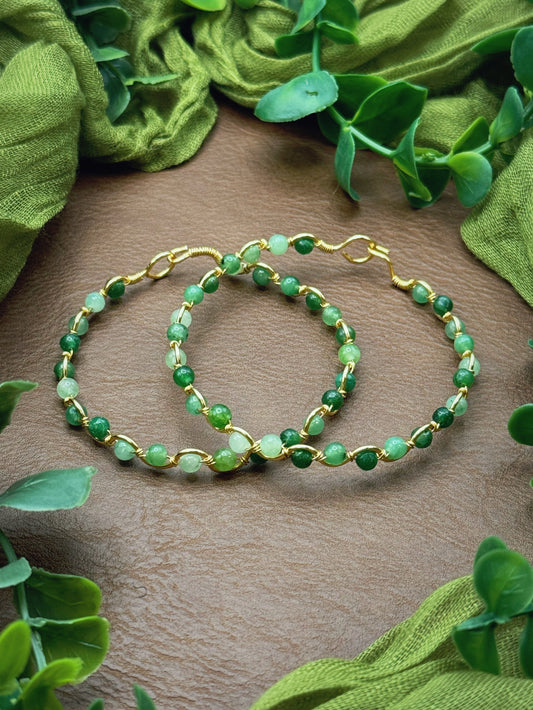 Handmade, wire-wrapped bracelet shaped like a wave, featuring green jade gemstone beads.