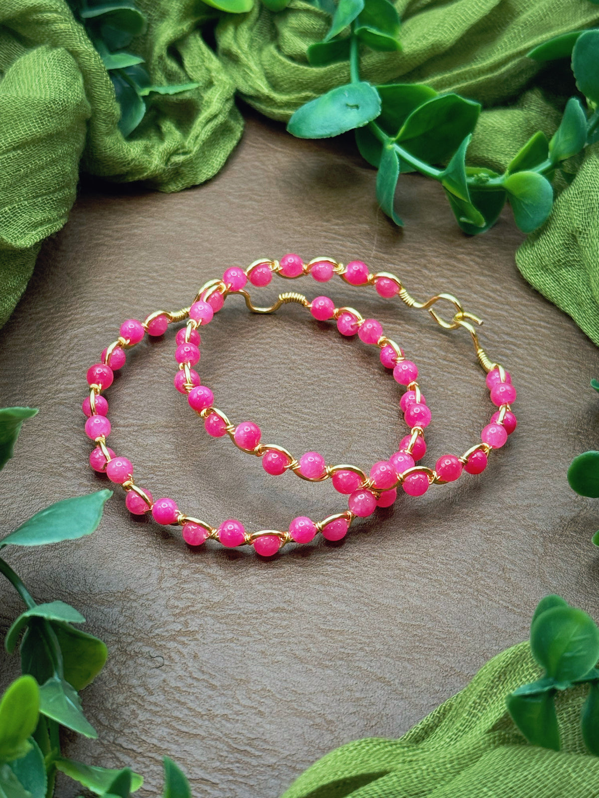 Handmade, wire-wrapped bracelet shaped like a wave, featuring hot pink czech glass beads.