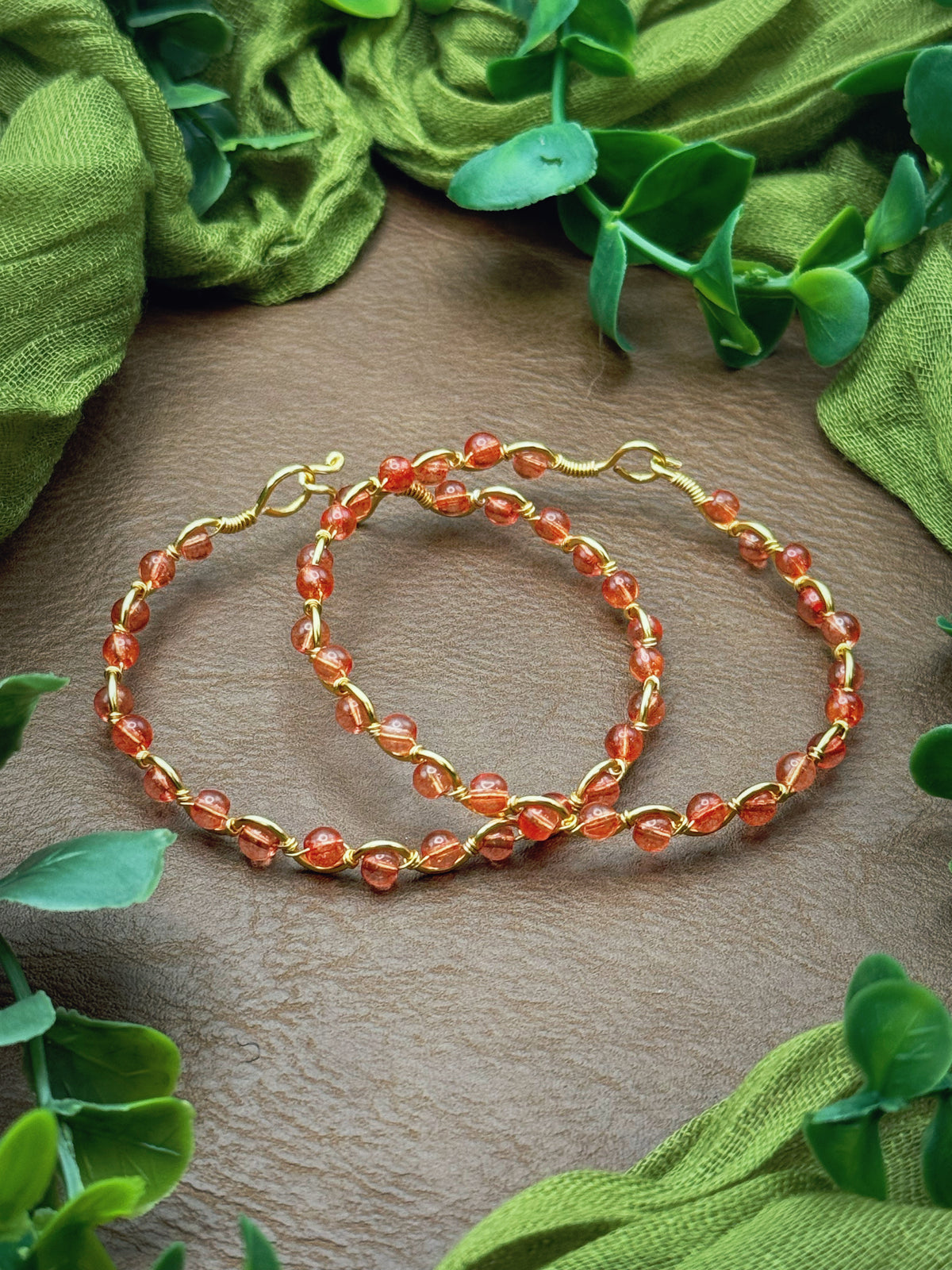 Handmade, wire-wrapped bracelet shaped like a wave, featuring pink dyed quartz gemstone beads.