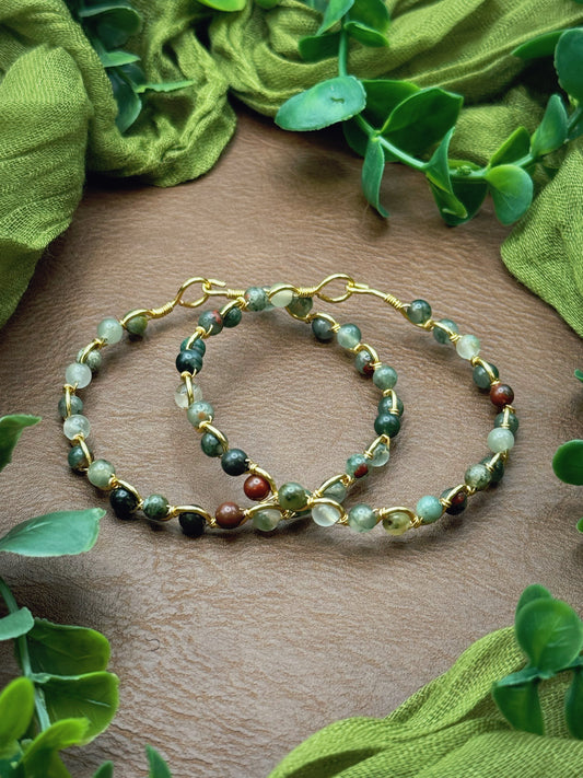 Handmade, wire-wrapped bracelet shaped like a wave, featuring green setonite african bloodstone gemstone beads.