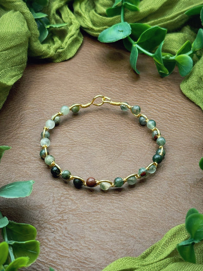 Handmade, wire-wrapped bracelet shaped like a wave, featuring green setonite african bloodstone gemstone beads.