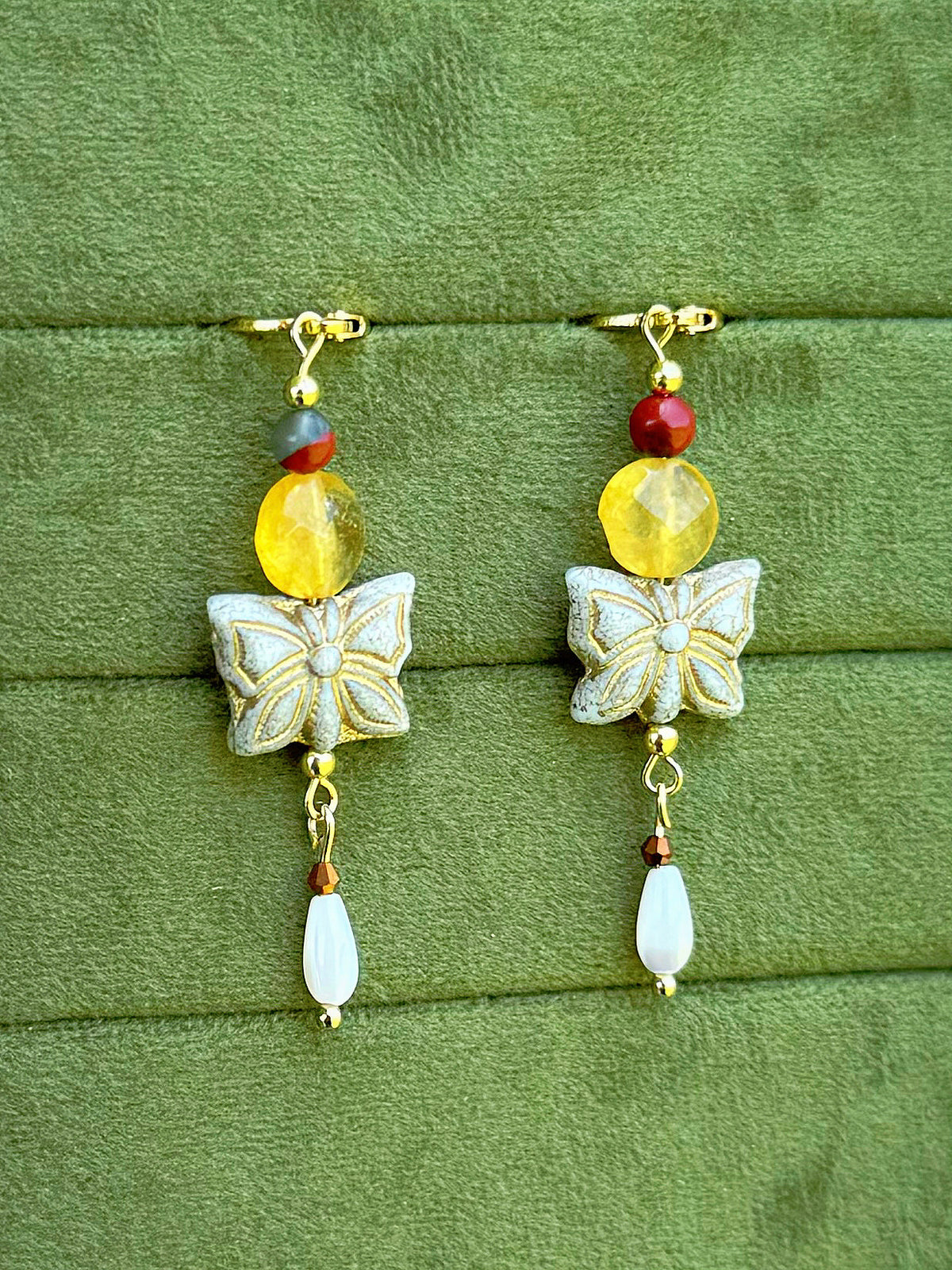 Handmade beaded earrings with gemstone and Czech glass beads on a olive green velvet background.