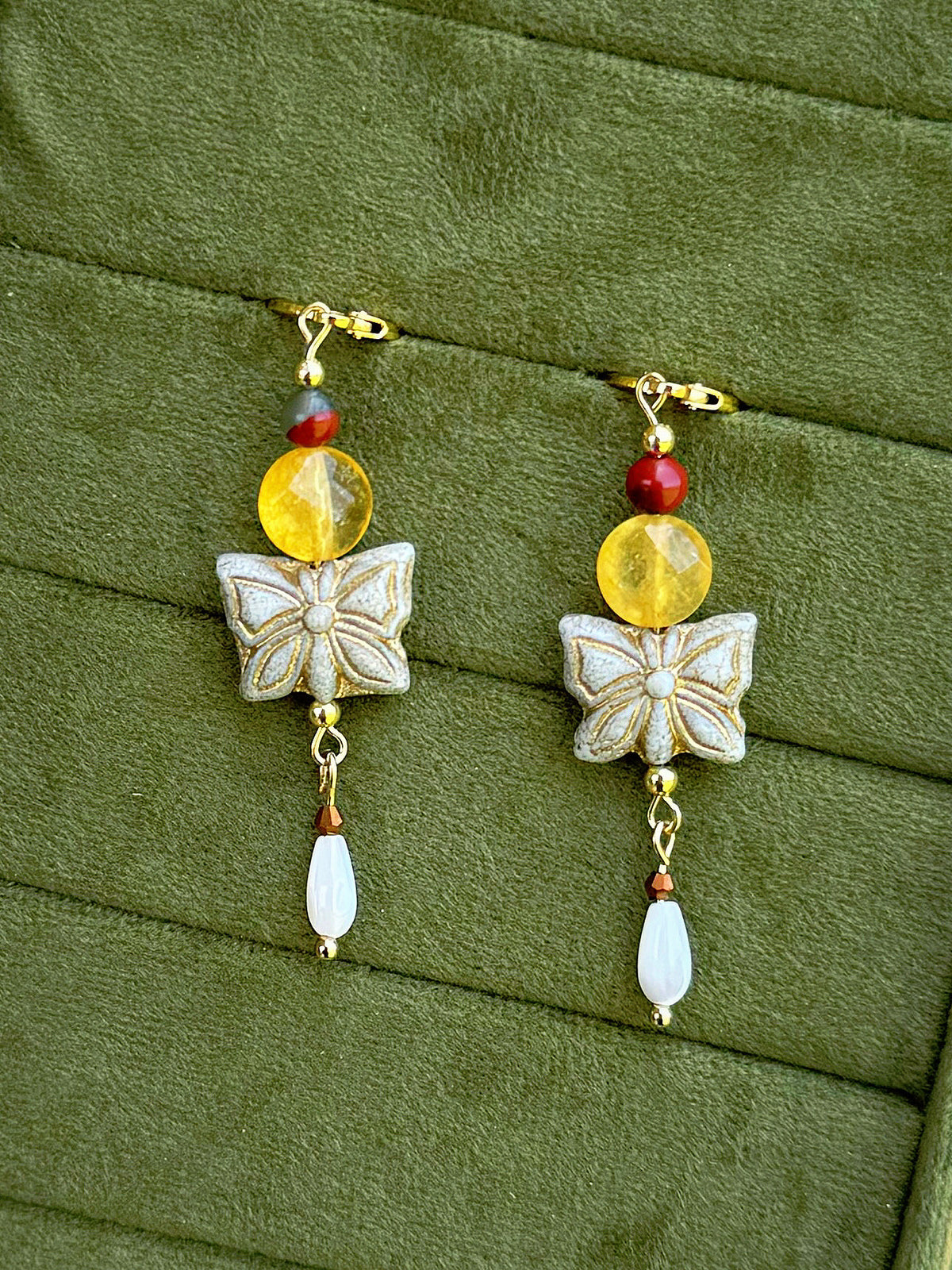 Handmade beaded earrings with gemstone and Czech glass beads on a olive green velvet background.