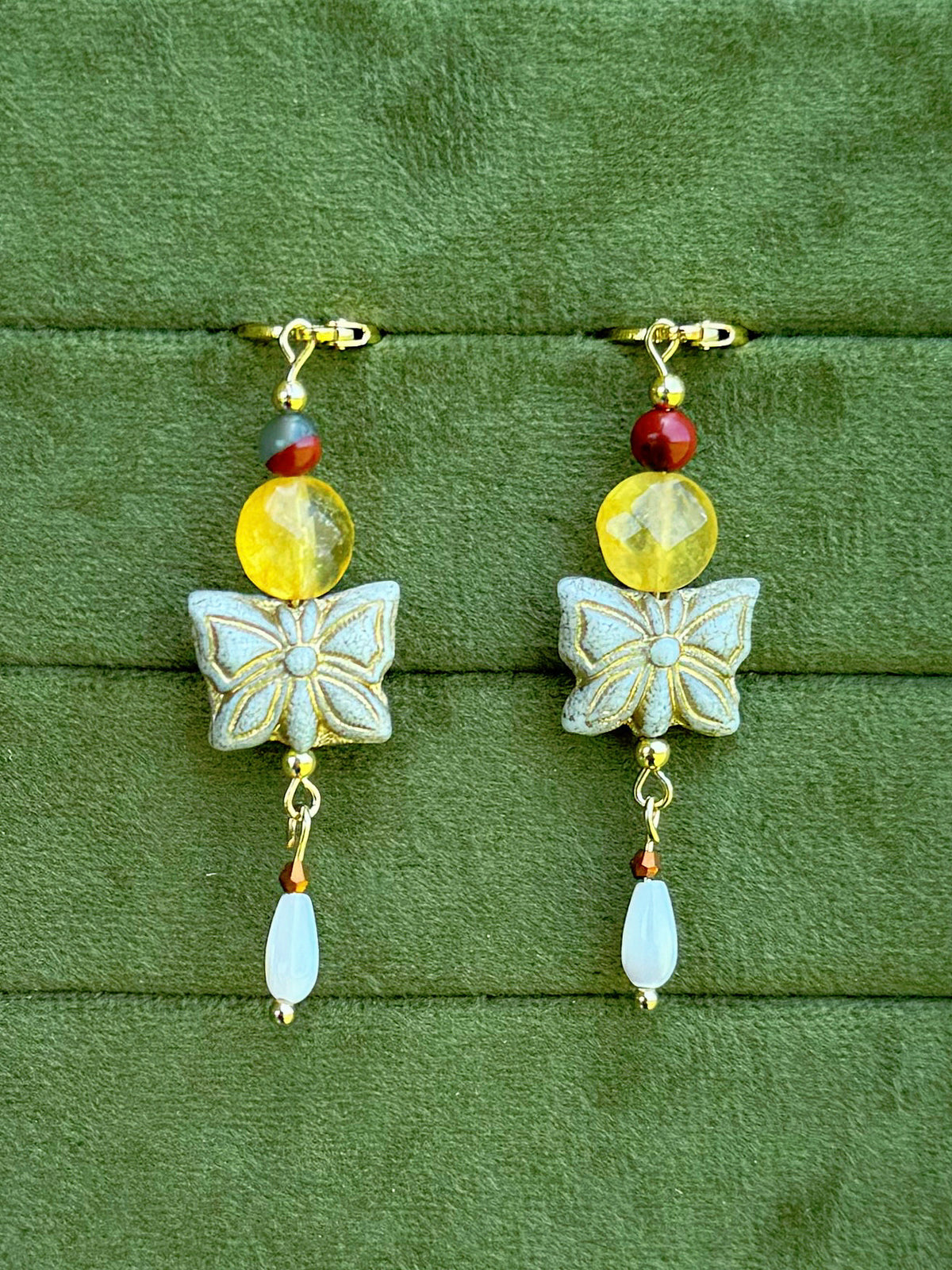 Handmade beaded earrings with gemstone and Czech glass beads on a olive green velvet background.