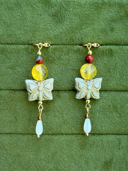 Handmade beaded earrings with gemstone and Czech glass beads on a olive green velvet background.