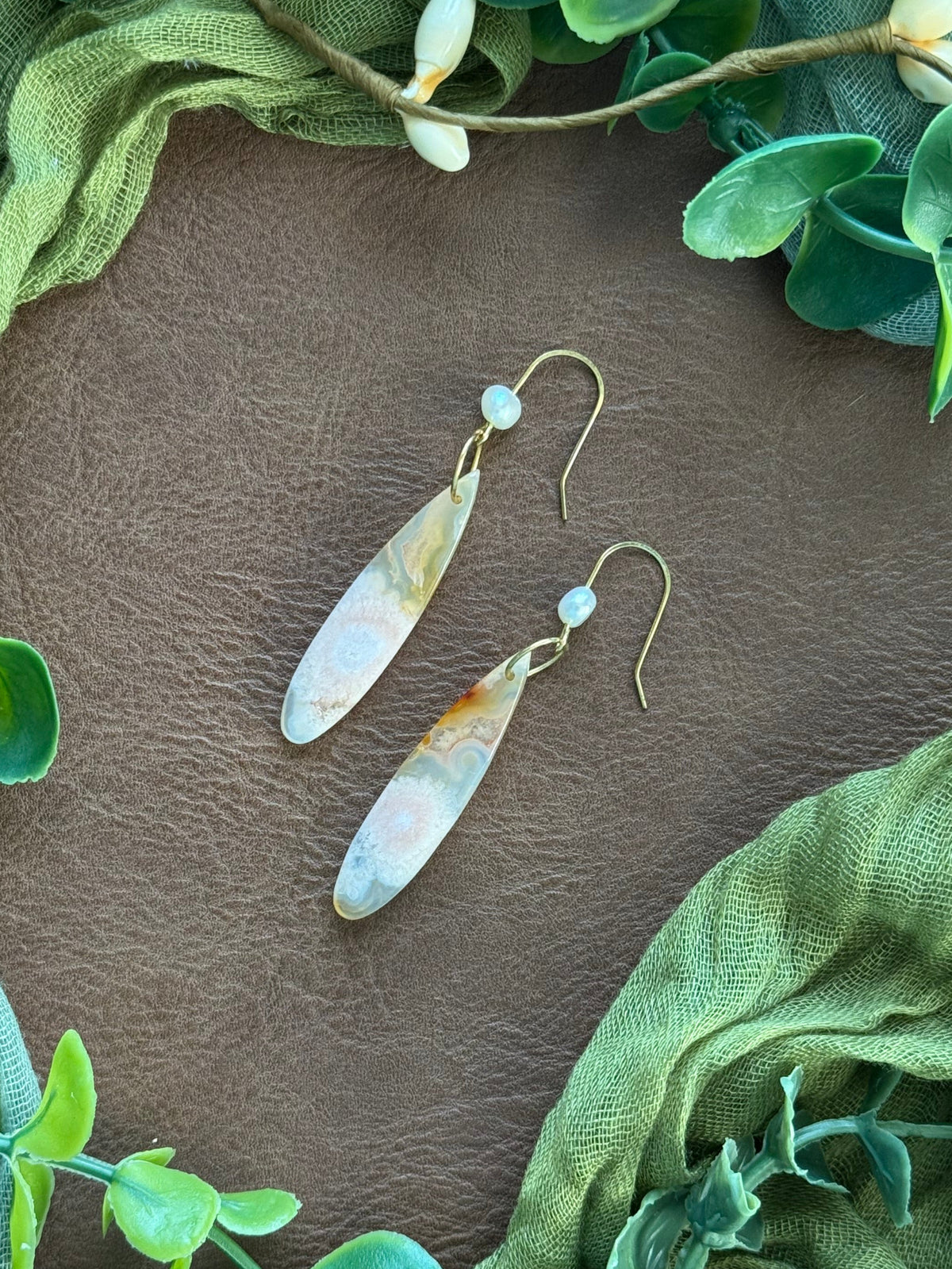 Handmade earrings with sakura agate teardrop beads, a dainty freshwater pearl, and gold ear hooks,.