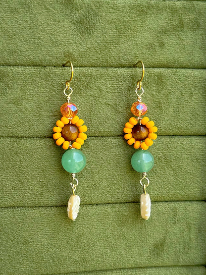 Handmade beaded floral earrings with gemstone and glass beads on an olive green velvet background.
