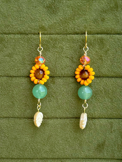 Handmade beaded floral earrings with gemstone and glass beads on an olive green velvet background.