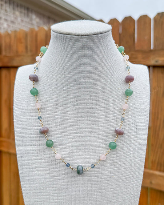 Beaded necklace featuring handmade wire links with blue, green, and pink gemstone beads.