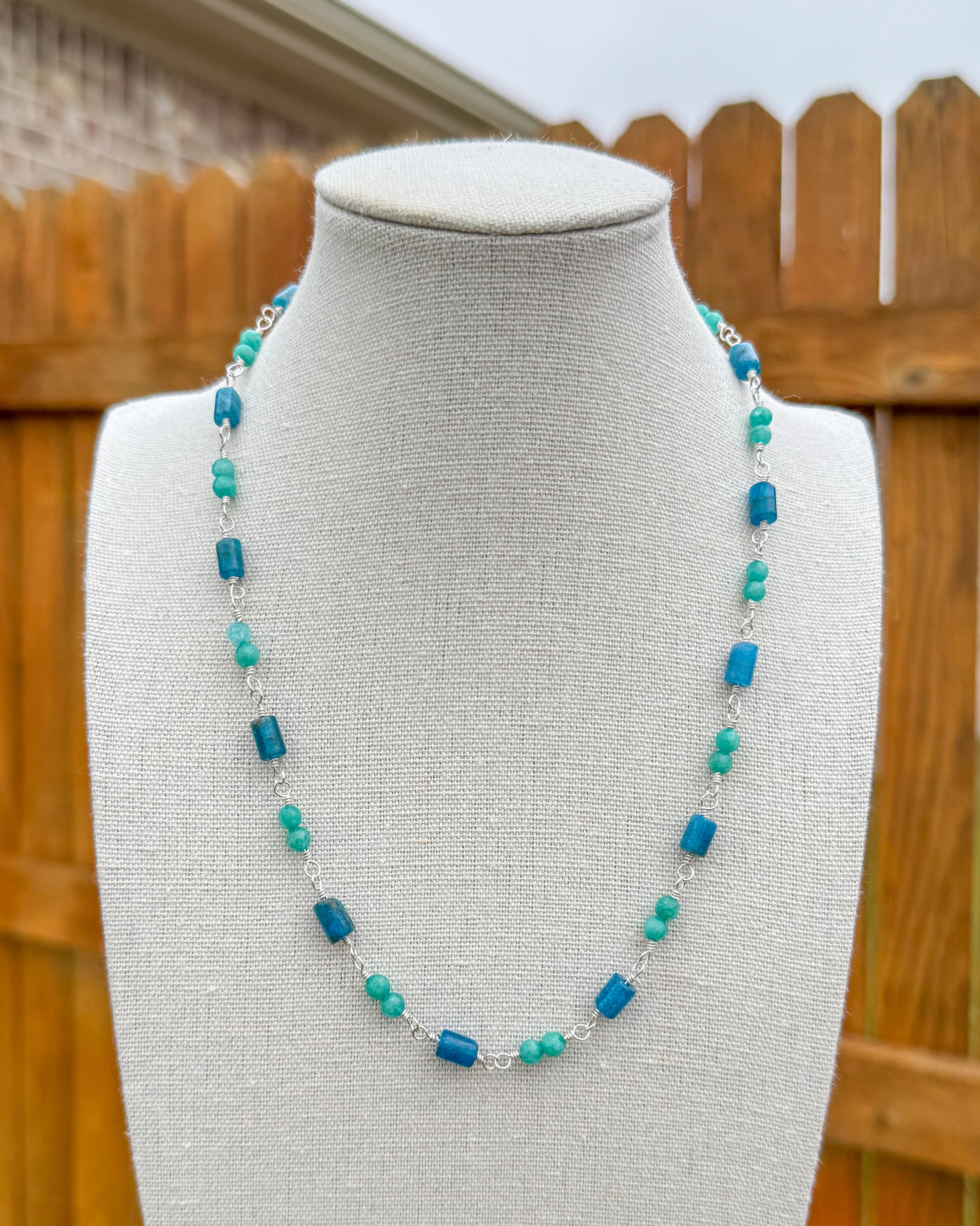 Beaded necklace featuring handmade wire links with blue and aqua gemstone beads.