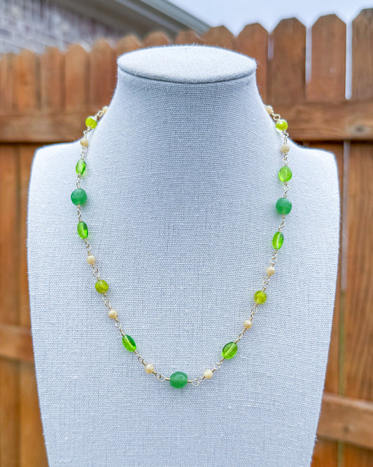 Beaded necklace featuring handmade wire links with green and ivory glass beads.