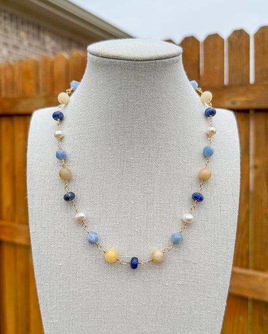 Beaded necklace featuring handmade wire links with blue, yellow, and white gemstone beads and pearls.